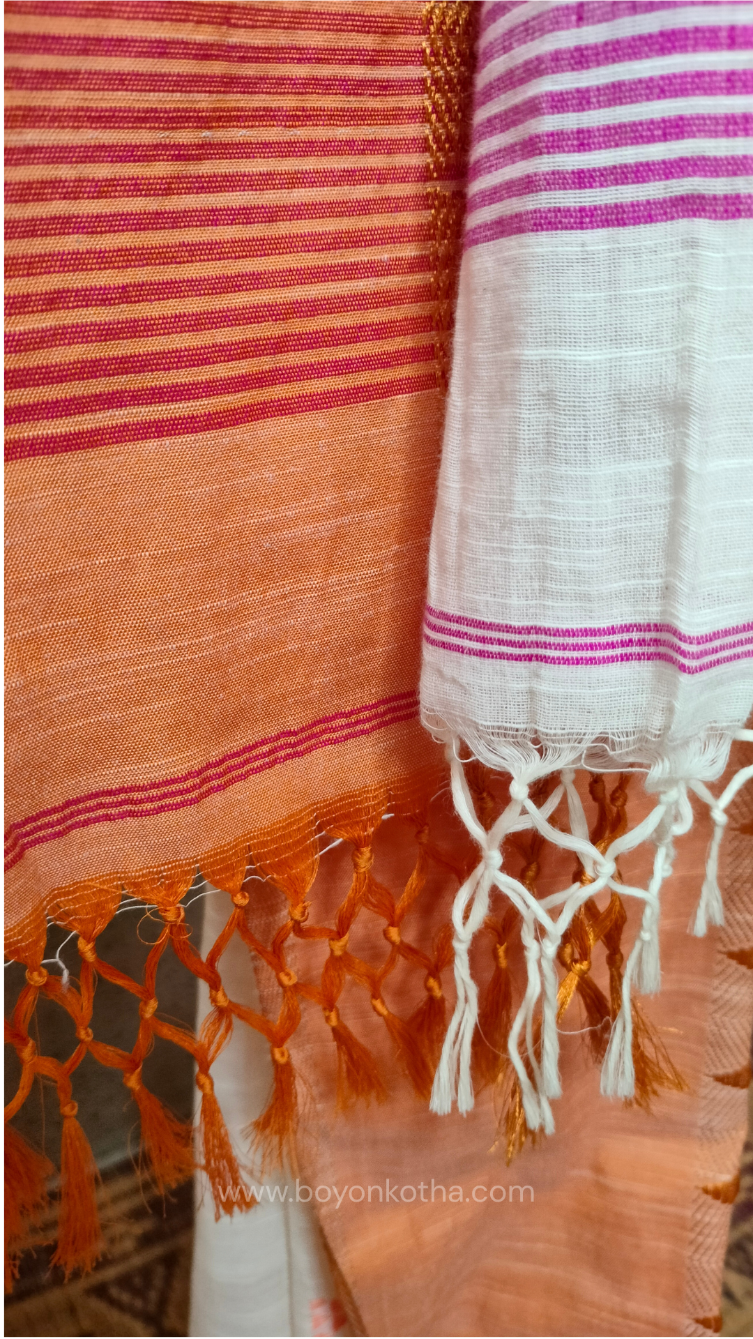 Off-white Bengal handloom cotton saree with ganga-jamuna border in orange and pink. Geometric woven motifs adorn the body, while the pallu features triangular patterns and tasseled ends. 