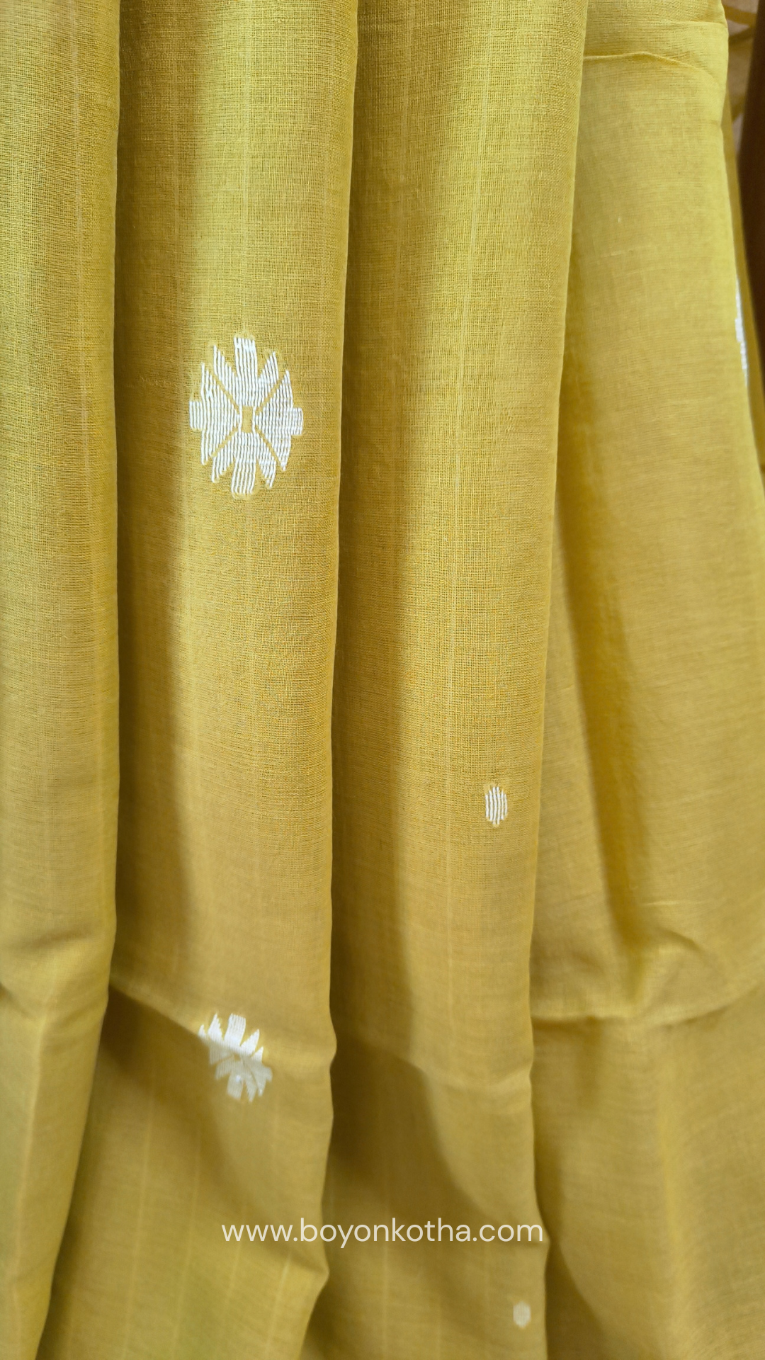 Greenish yellow buttery soft handloom cotton saree, with jamdani inspired handloom jacquard woven butas all over and braided tassels. Ideal for festive mornings 