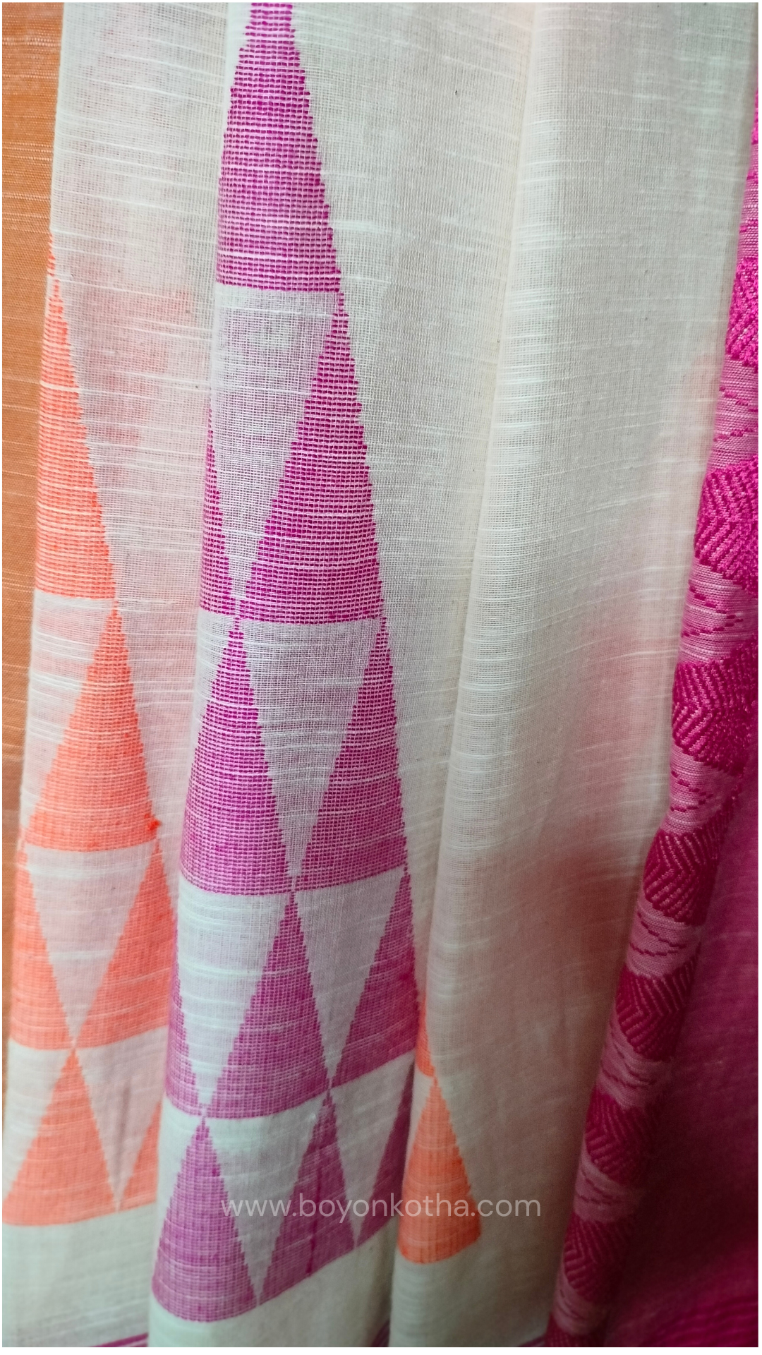 Off-white Bengal handloom cotton saree with ganga-jamuna border in orange and pink. Geometric woven motifs adorn the body, while the pallu features triangular patterns and tasseled ends. 