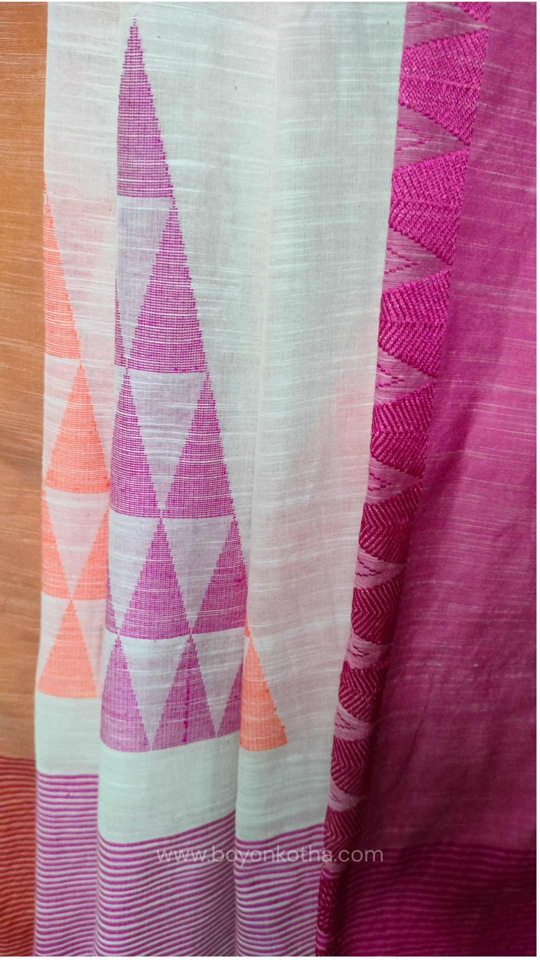 Off-white Bengal handloom cotton saree with ganga-jamuna border in orange and pink. Geometric woven motifs adorn the body, while the pallu features triangular patterns and tasseled ends. 