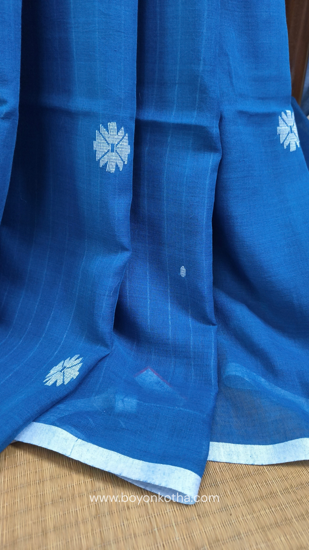 Blue buttery soft handloom cotton saree, with jamdani inspired handloom jacquard woven butas all over and braided tassels. Ideal for festive mornings 