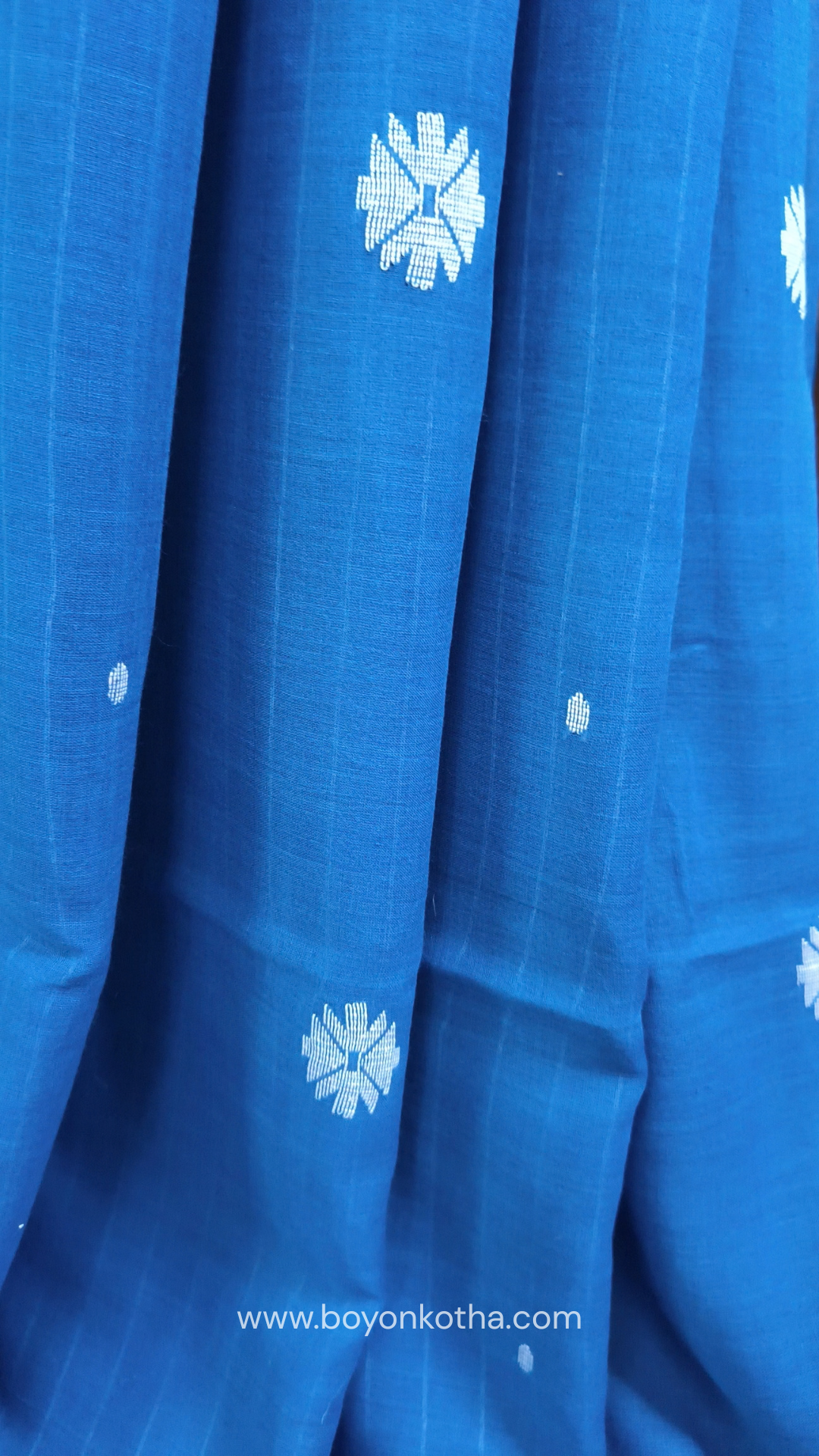 Blue buttery soft handloom cotton saree, with jamdani inspired handloom jacquard woven butas all over and braided tassels. Ideal for festive mornings 