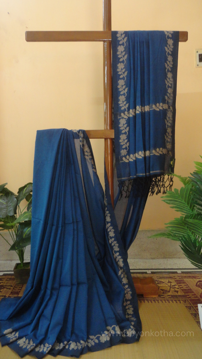 Blue handwoven cotton saree, with woven beige floral vines running across the border till the pallu; bengal handloom, blue saree