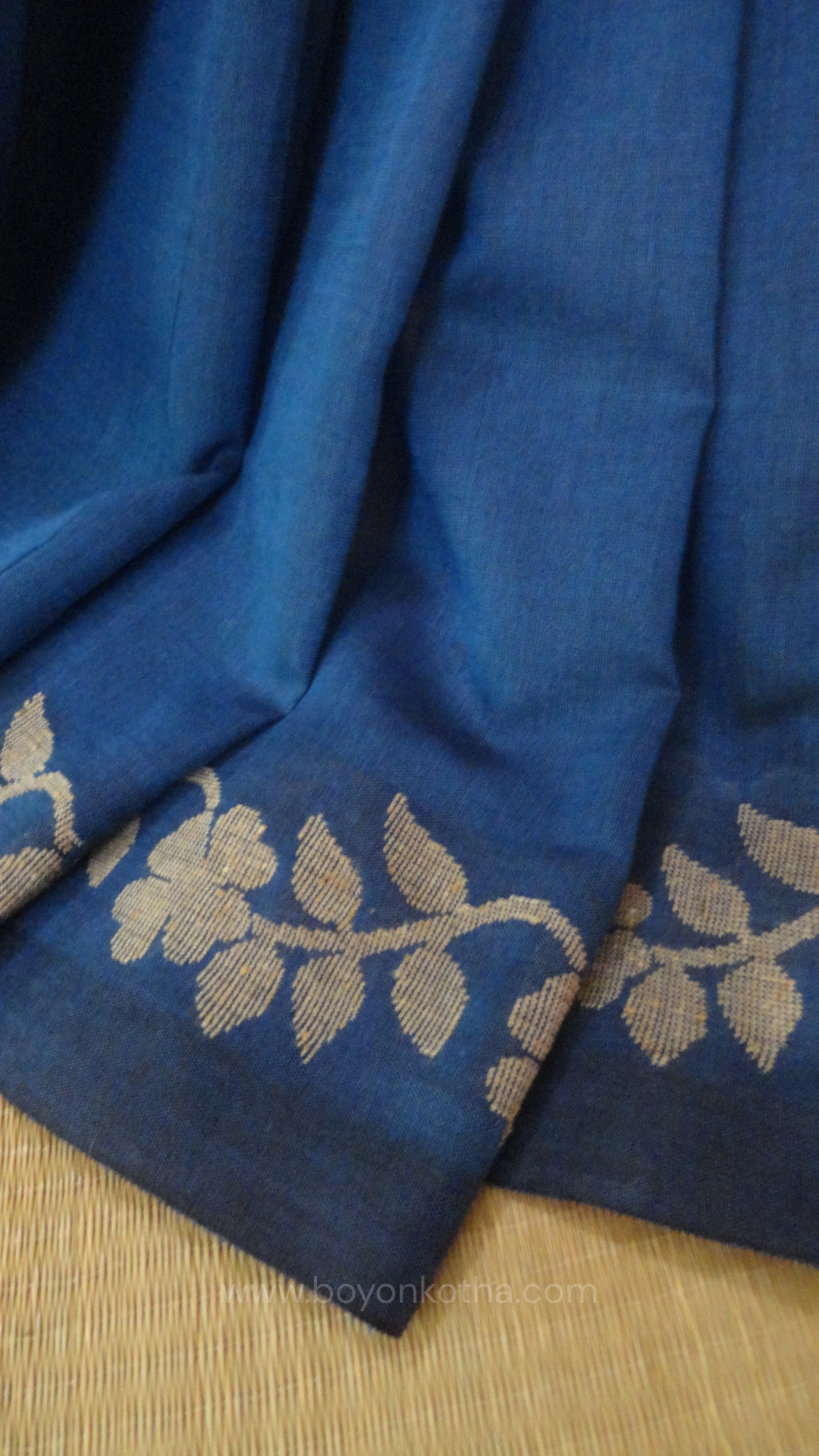 Blue handwoven cotton saree, with woven beige floral vines running across the border till the pallu; bengal handloom, blue saree