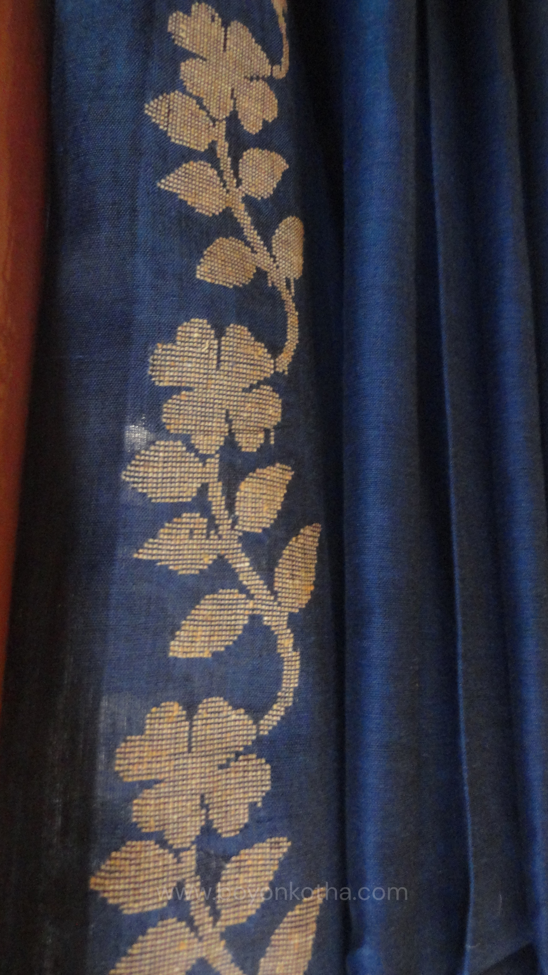 Blue handwoven cotton saree, with woven beige floral vines running across the border till the pallu; bengal handloom, blue saree