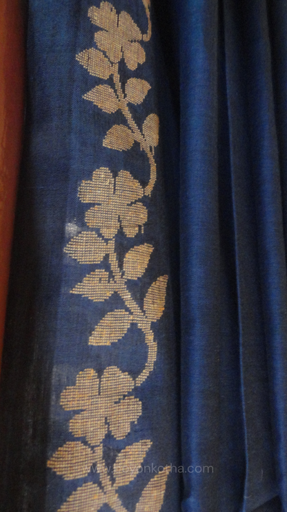 Blue handwoven cotton saree, with woven beige floral vines running across the border till the pallu; bengal handloom, blue saree