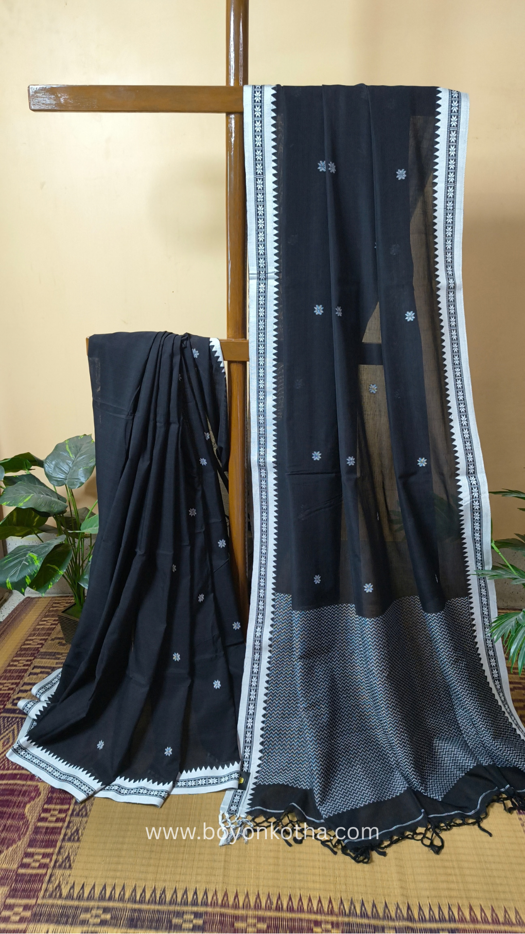 Black handloom cotton saree with white woven jamdani-inspired jacquard butis and nakshi border. Perfect for festivals and cultural gatherings.