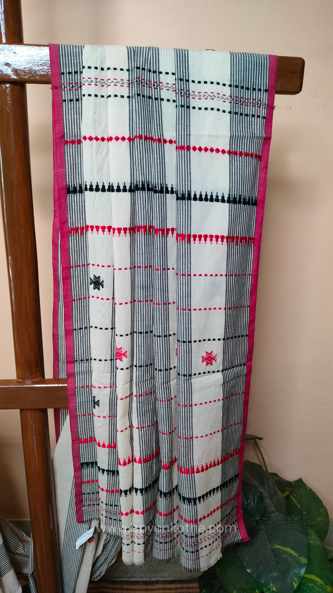 Elegant off-white Dhonekhali handloom cotton saree featuring striking black stripes and woven red and black motifs.