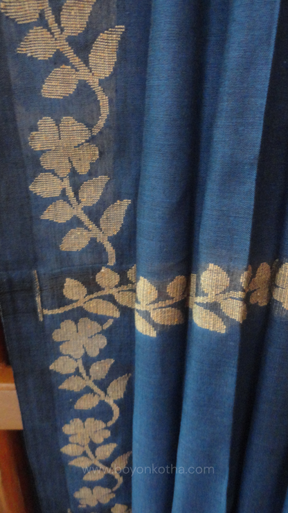 Blue handwoven cotton saree, with woven beige floral vines running across the border till the pallu; bengal handloom, blue saree