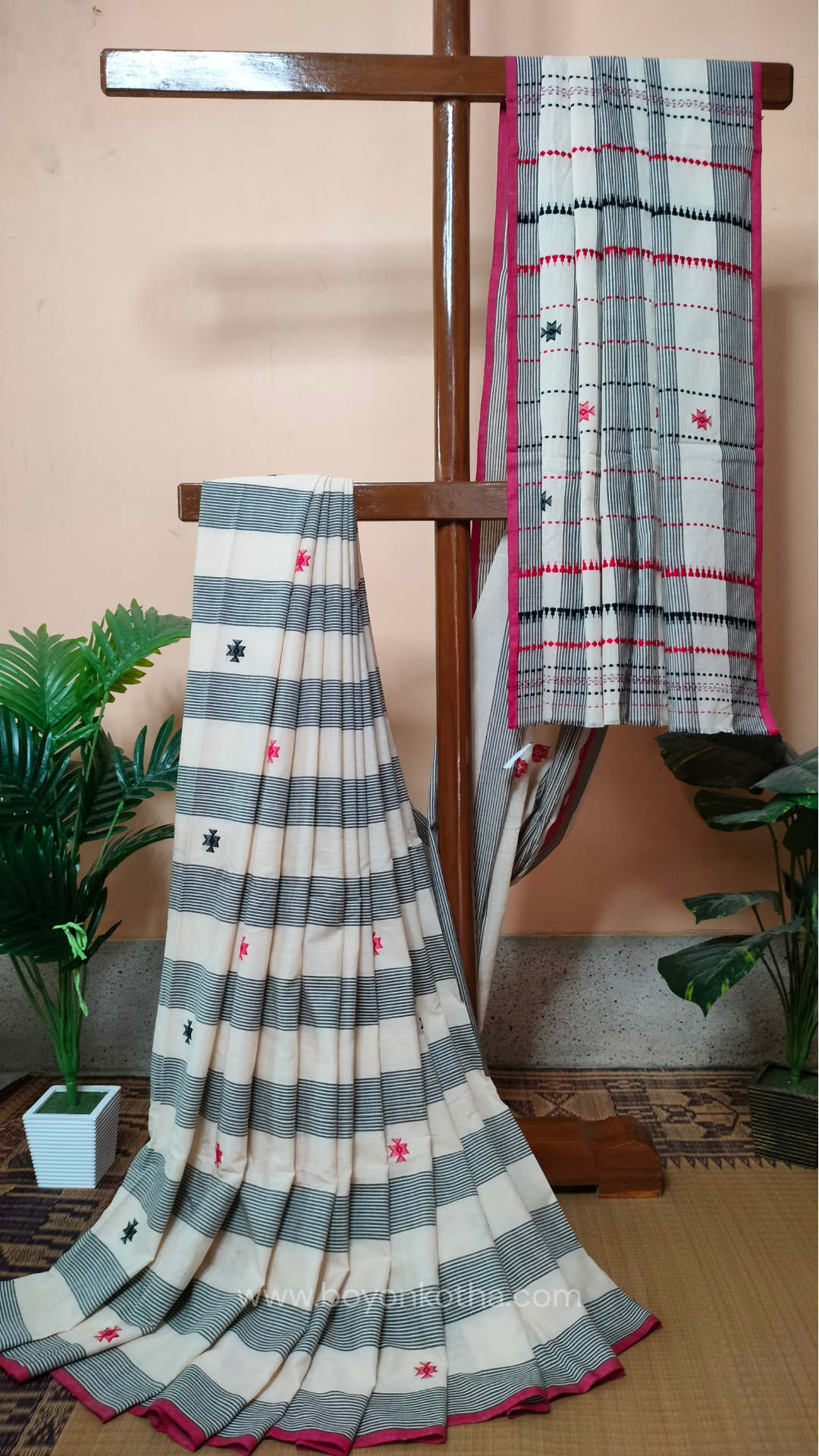 Elegant off-white Dhonekhali handloom cotton saree featuring striking black stripes and woven red and black motifs.