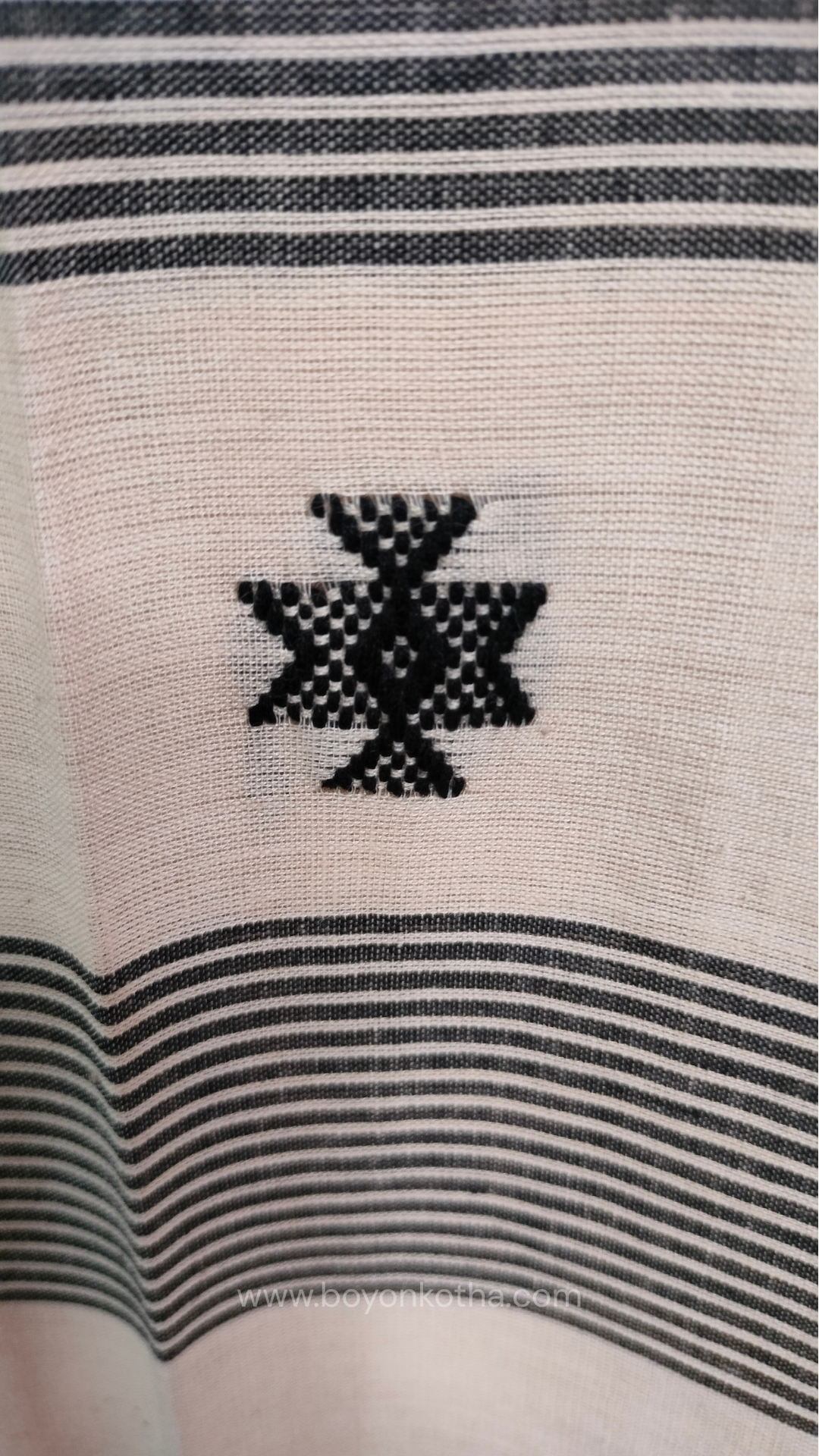 Elegant off-white Dhonekhali handloom cotton saree featuring striking black stripes and woven red and black motifs.