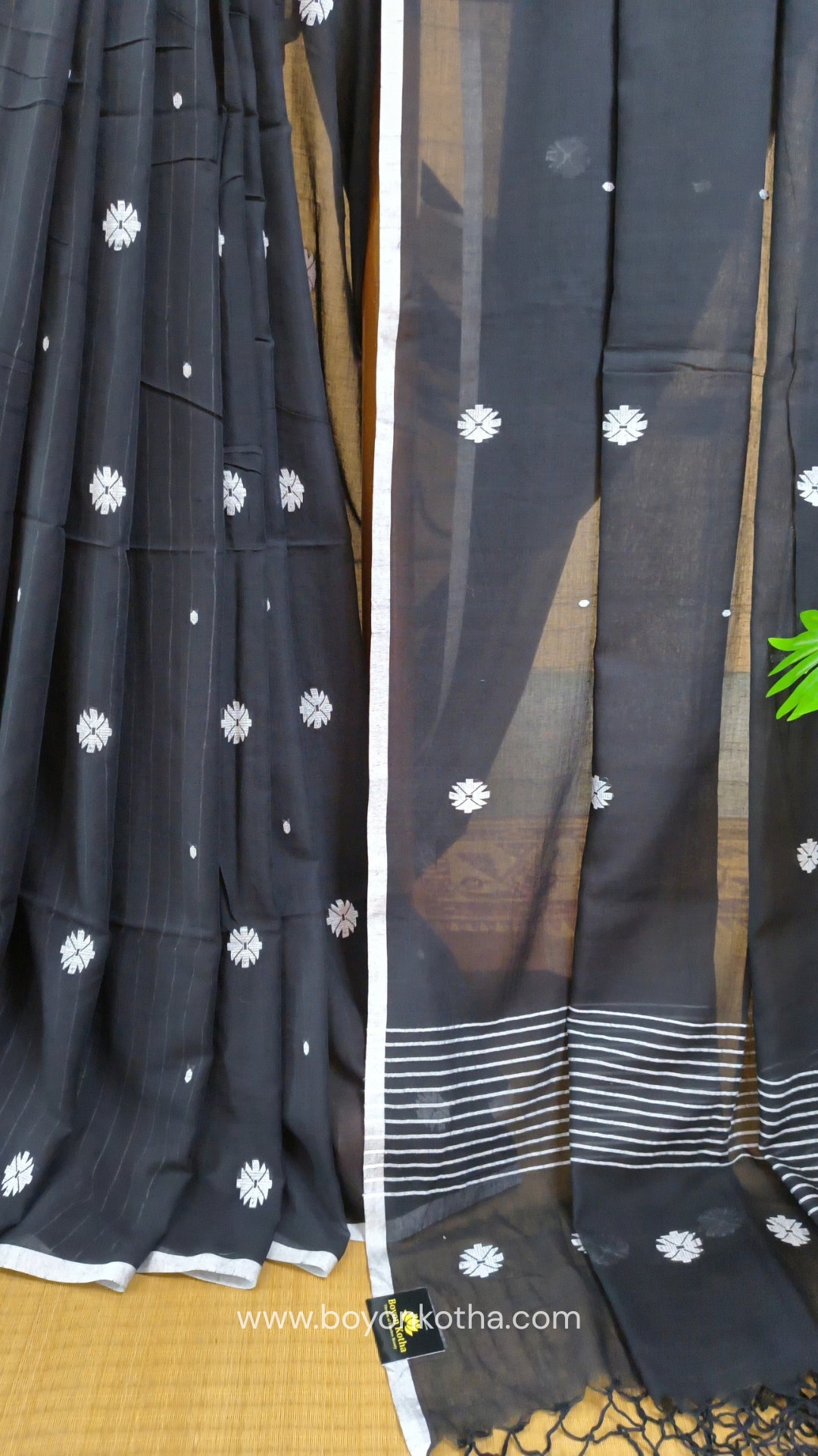 Black buttery soft handloom cotton saree, with jamdani inspired handloom jacquard woven butas all over and braided tassels. Ideal for festive mornings 