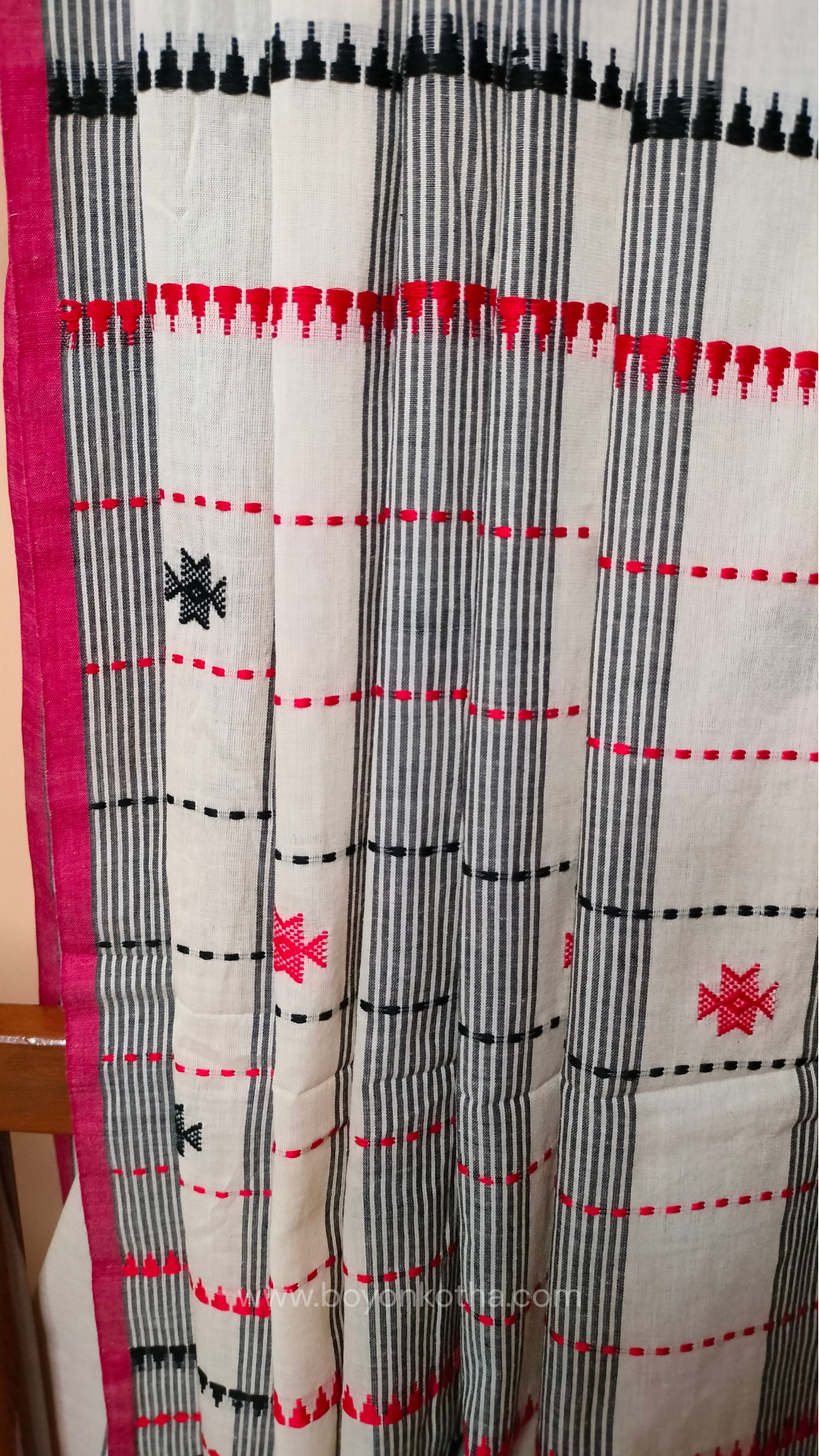 Elegant off-white Dhonekhali handloom cotton saree featuring striking black stripes and woven red and black motifs.
