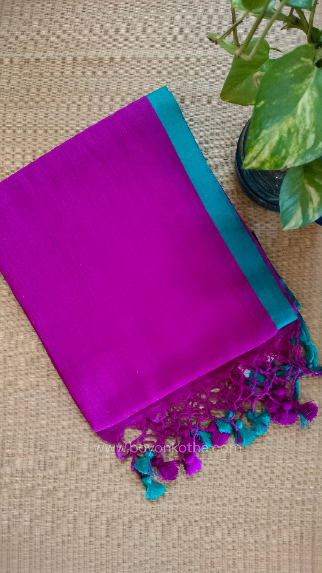 Magenta handwoven mul cotton saree with rama green border, pallu ending in tassels. Plain handloom saree from Bengal.
