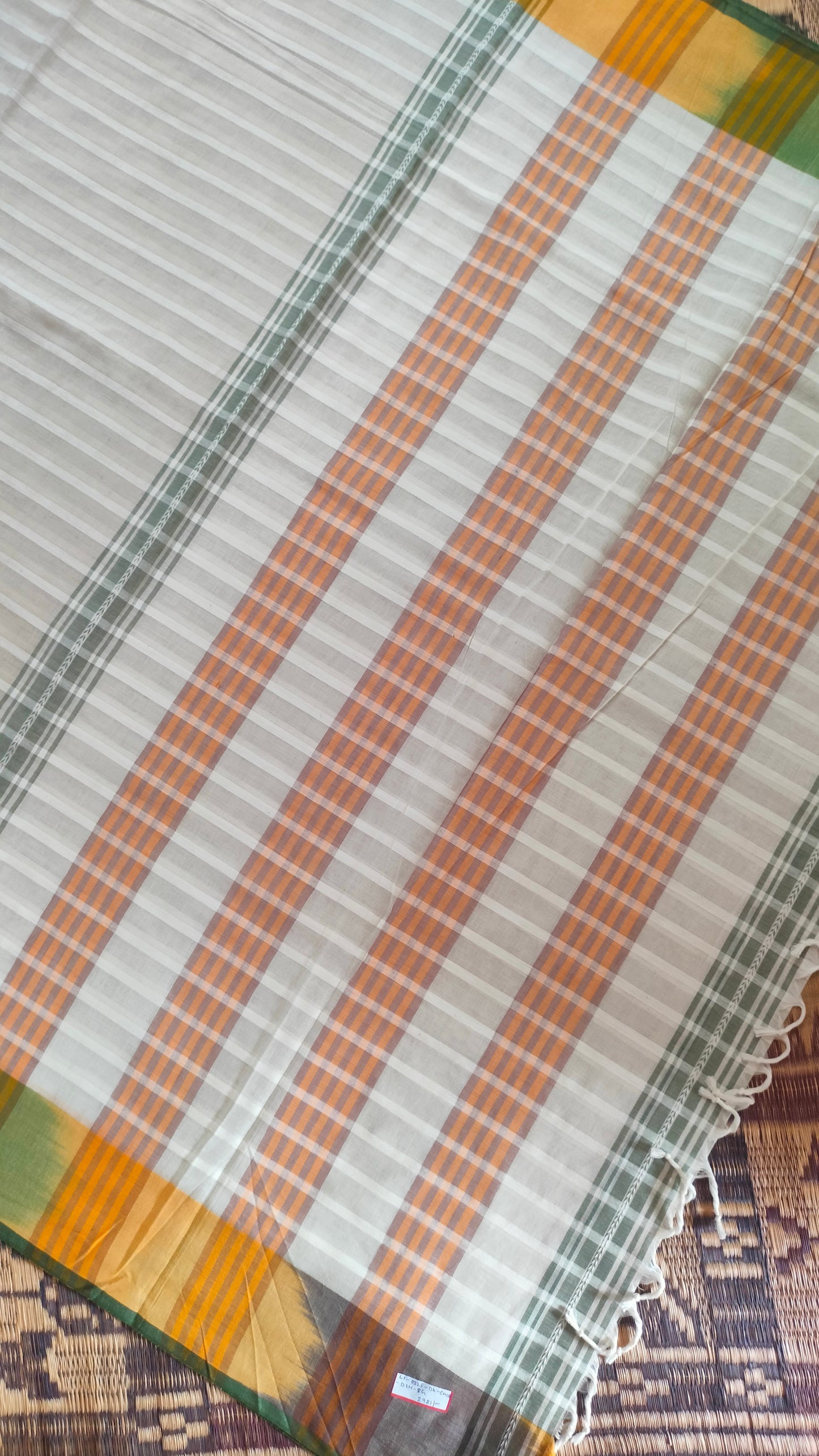 Dhonekhali handloom cotton saree with a striped body in alternating off-white and cream tones, complemented by a vibrant multi-hued border in green, purple, and yellow abstract patterns. Finished with tassel details at the pallu.
