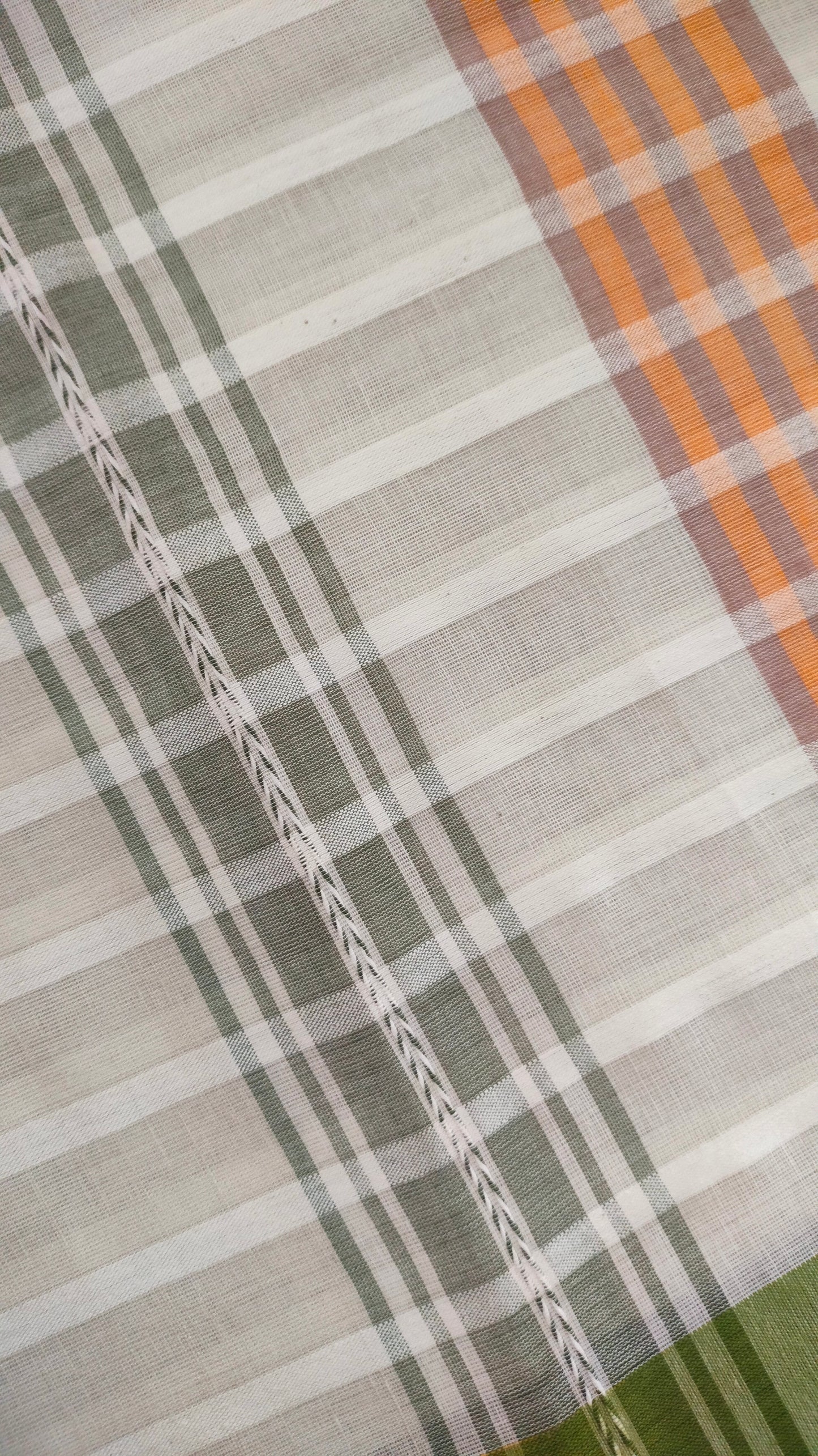 Dhonekhali handloom cotton saree with a striped body in alternating off-white and cream tones, complemented by a vibrant multi-hued border in green, purple, and yellow abstract patterns. Finished with tassel details at the pallu.