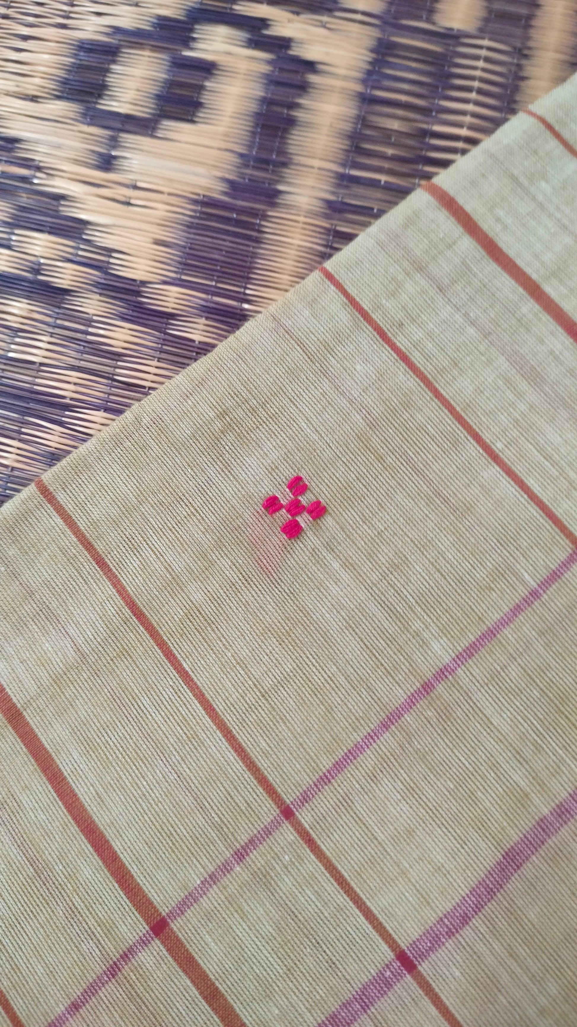 Close-up of Beige and red Dhonekhali handloom cotton saree with woven red stripes and motifs throughout the saree. Bengal handloom cotton.