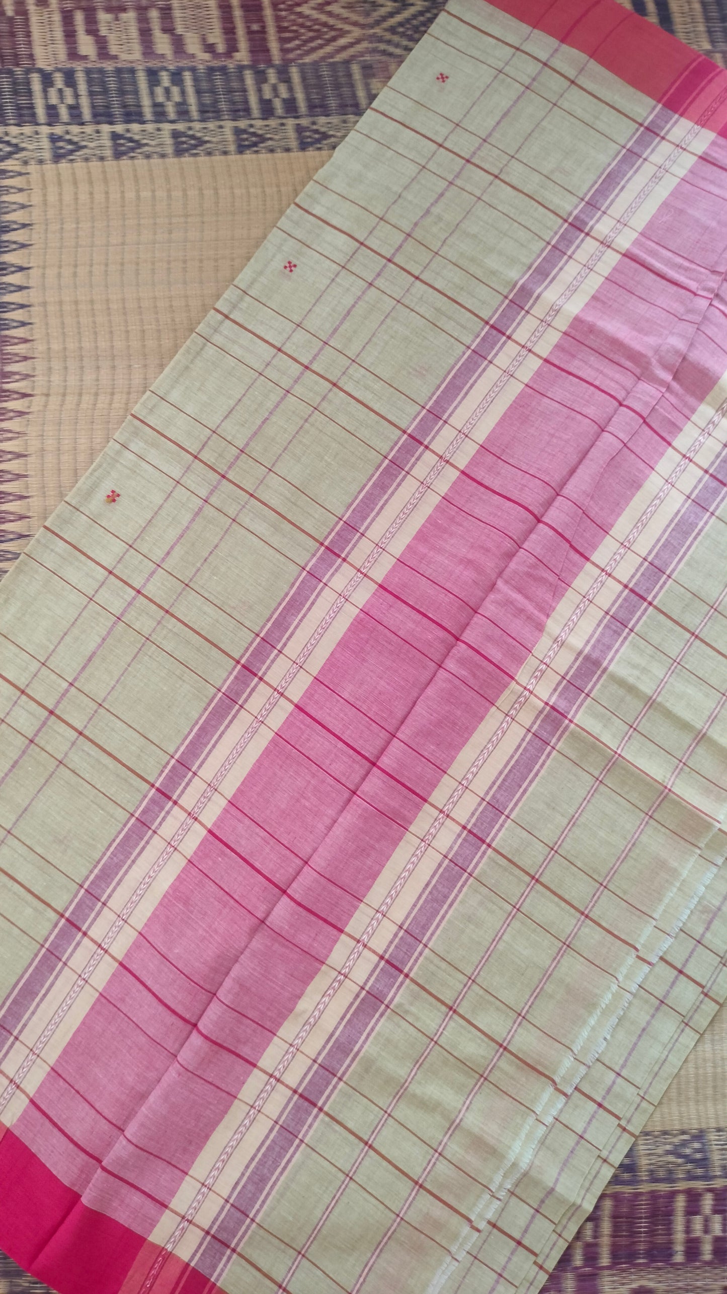 Pallu of Beige and red Dhonekhali handloom cotton saree with woven red stripes and motifs throughout the saree. Bengal handloom cotton.