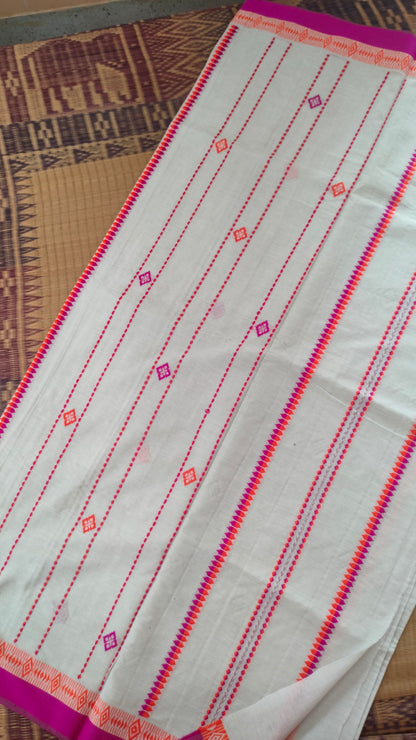A white Dhonekhali handloom cotton saree with orange and pink woven motifs and bands on the saree. The border of the saree is pink with the inner edge having orange motifs.