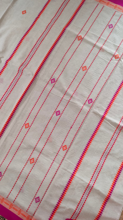A white Dhonekhali handloom cotton saree with orange and pink woven motifs and bands on the saree. The border of the saree is pink with the inner edge having orange motifs.
