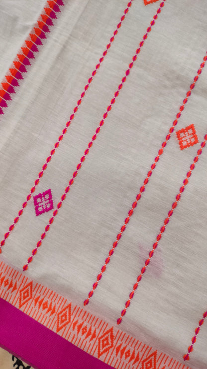 A white Dhonekhali handloom cotton saree with orange and pink woven motifs and bands on the saree. The border of the saree is pink with the inner edge having orange motifs.