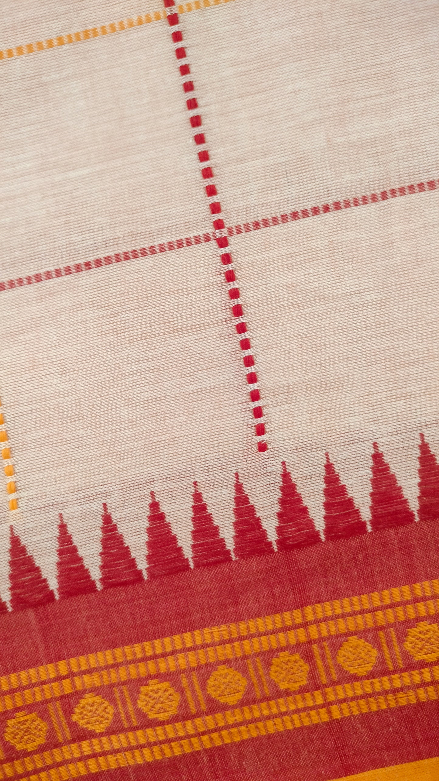 Close-up of Off-white Dhonekhali handloom cotton saree with woven red and yellow check patterns throughout the body. Ideal for festive, semi-festive gatherings and refined everyday wear.