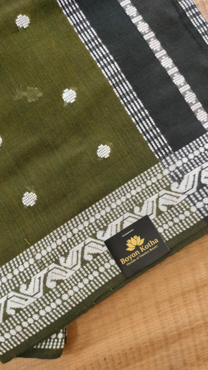 Olive Green Dhonekhali handloom cotton saree with woven white motifs across the body and the border with a black pallu that has woven white vertical stripes.