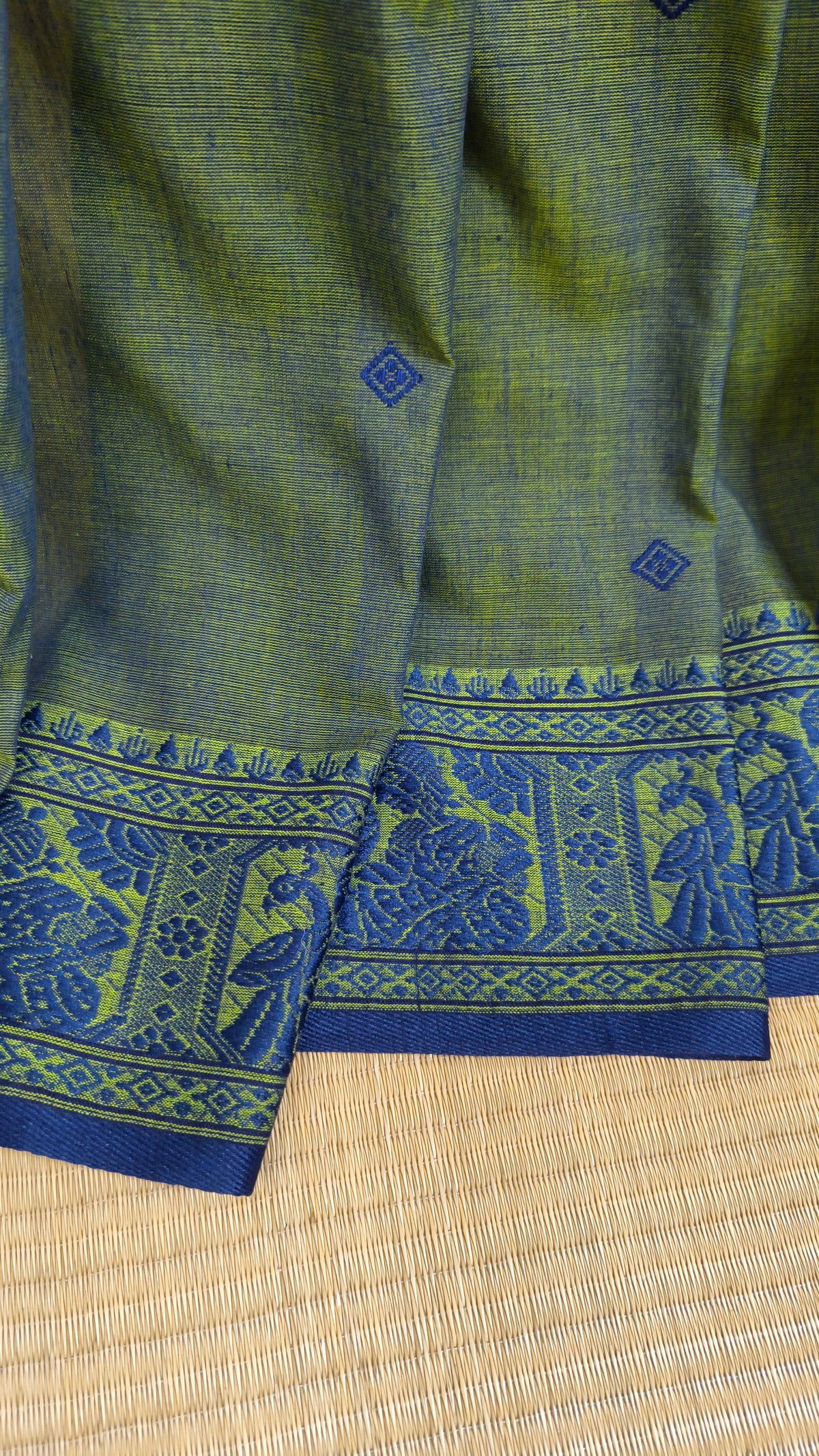Dual toned green-blue cotton baluchari saree, with woven motifs in the border & pallu in navy blue. Bengal handloom ideal for festivals & everyday celebrations.