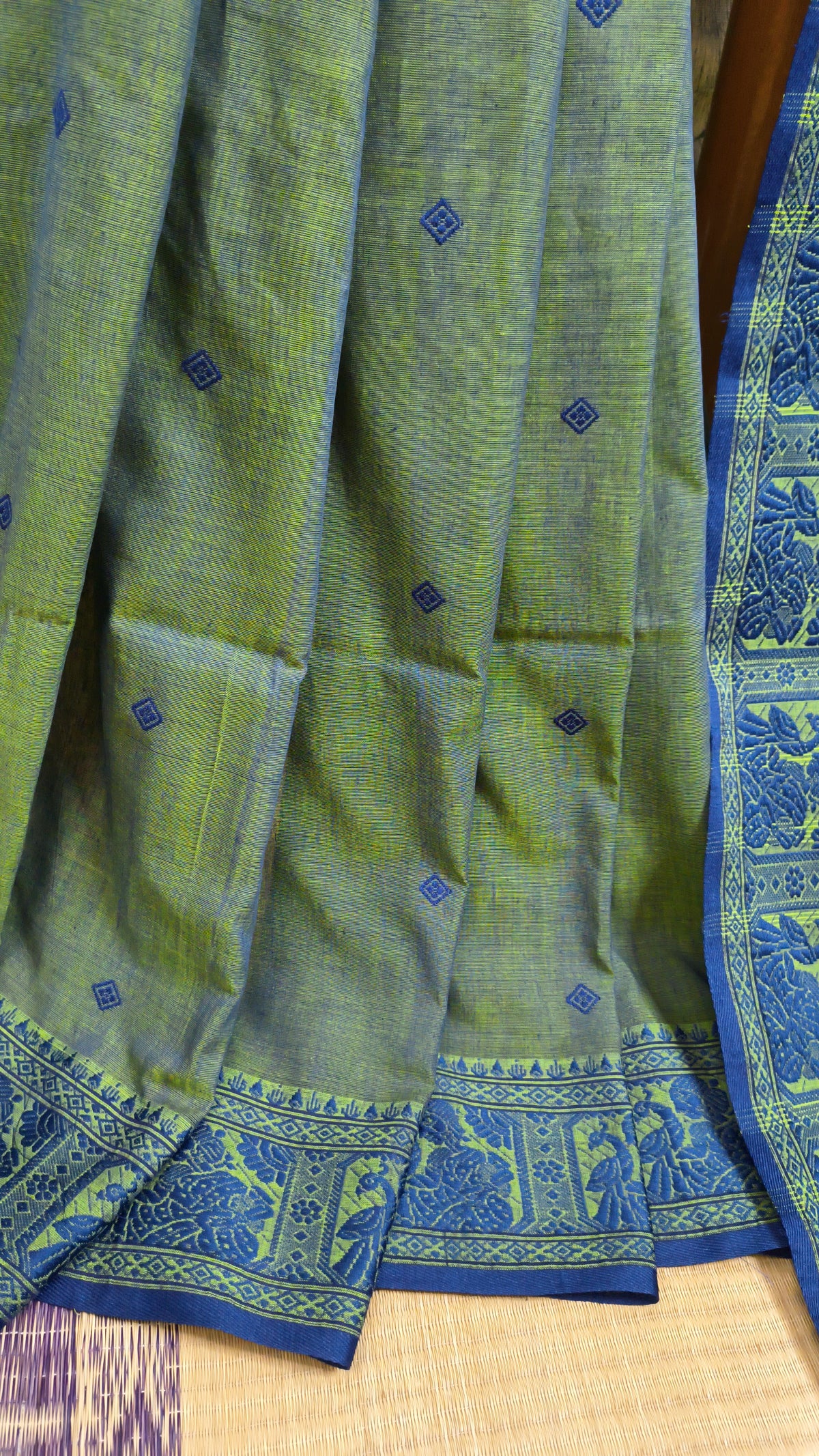 Dual toned green-blue cotton baluchari saree, with woven motifs in the border & pallu in navy blue. Bengal handloom ideal for festivals & everyday celebrations.