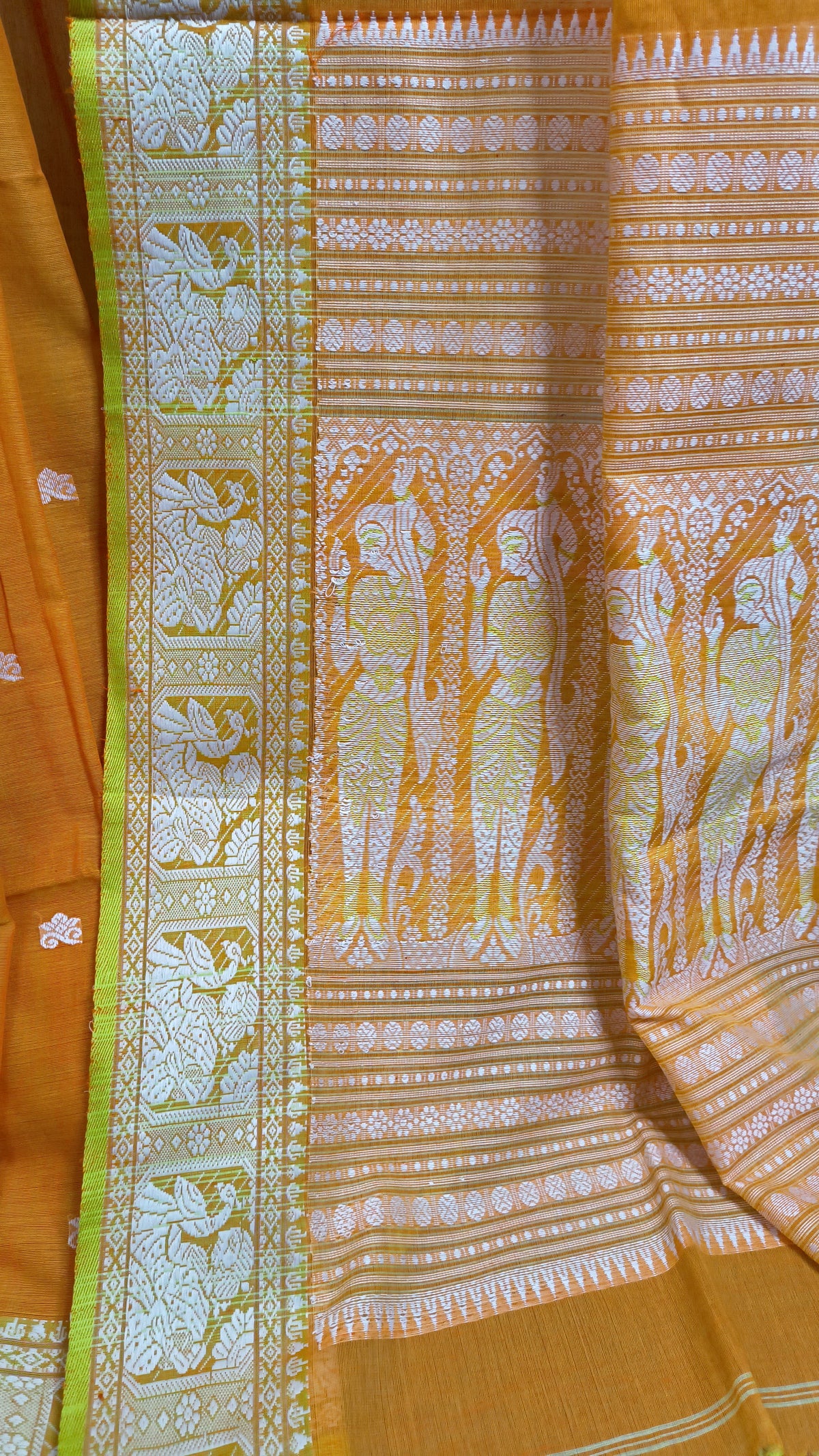 Orange cotton baluchari saree, with woven motifs in the border & pallu in white and neon green. Bengal handloom ideal for festivals & everyday celebrations.