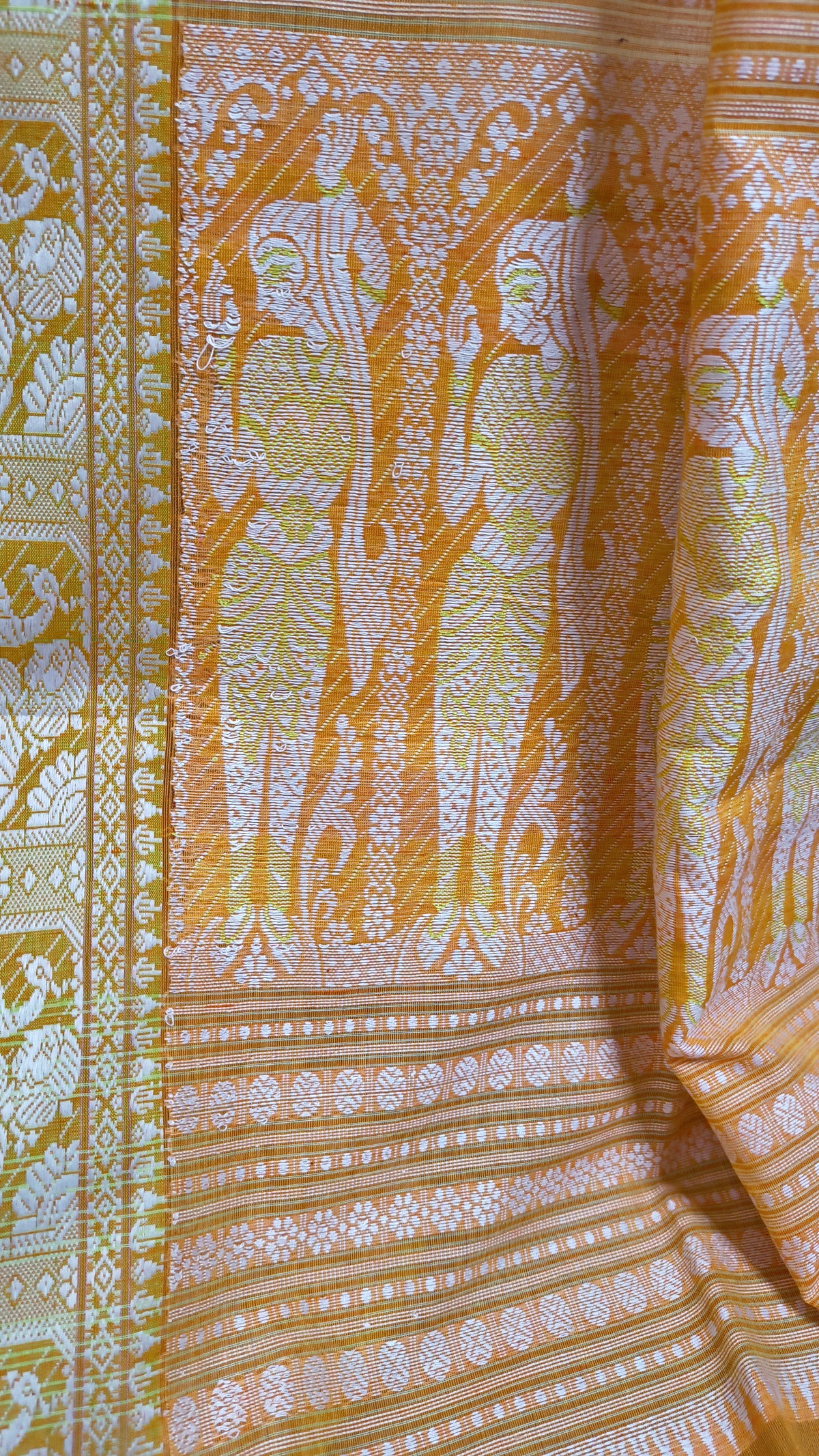 Orange cotton baluchari saree, with woven motifs in the border & pallu in white and neon green. Bengal handloom ideal for festivals & everyday celebrations.