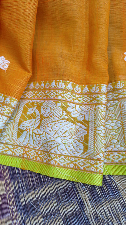 Orange cotton baluchari saree, with woven motifs in the border & pallu in white and neon green. Bengal handloom ideal for festivals & everyday celebrations.