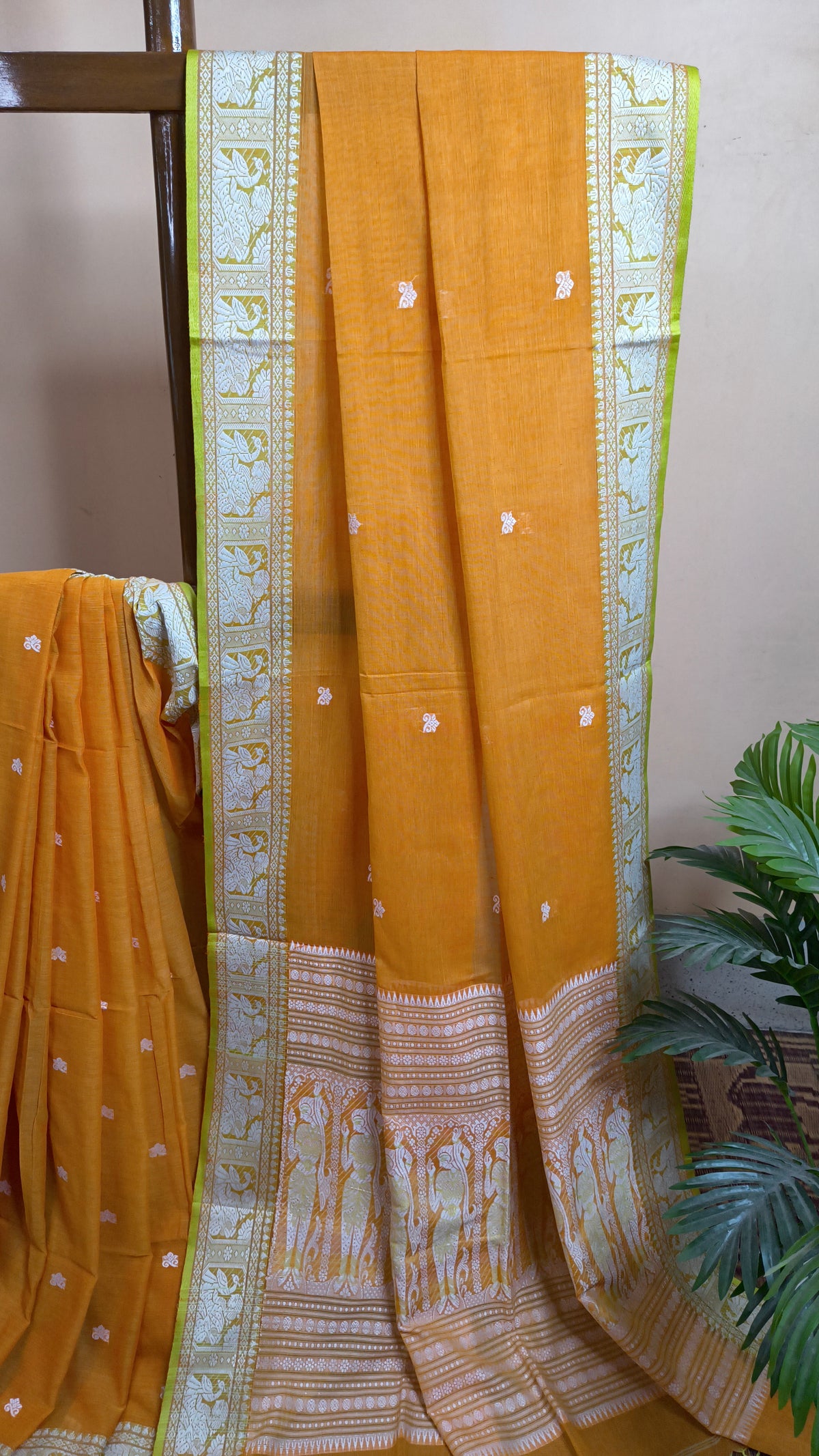 Orange cotton baluchari saree, with woven motifs in the border & pallu in white and neon green. Bengal handloom ideal for festivals & everyday celebrations.